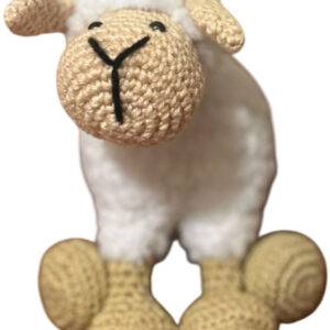 Ein gehäkeltes Schafspielzeug mit beigem Kopf, Ohren und Beinen, schwarz gestickten Gesichtszügen und einem weißen Körper, abgebildet vor einem weißen Hintergrund.